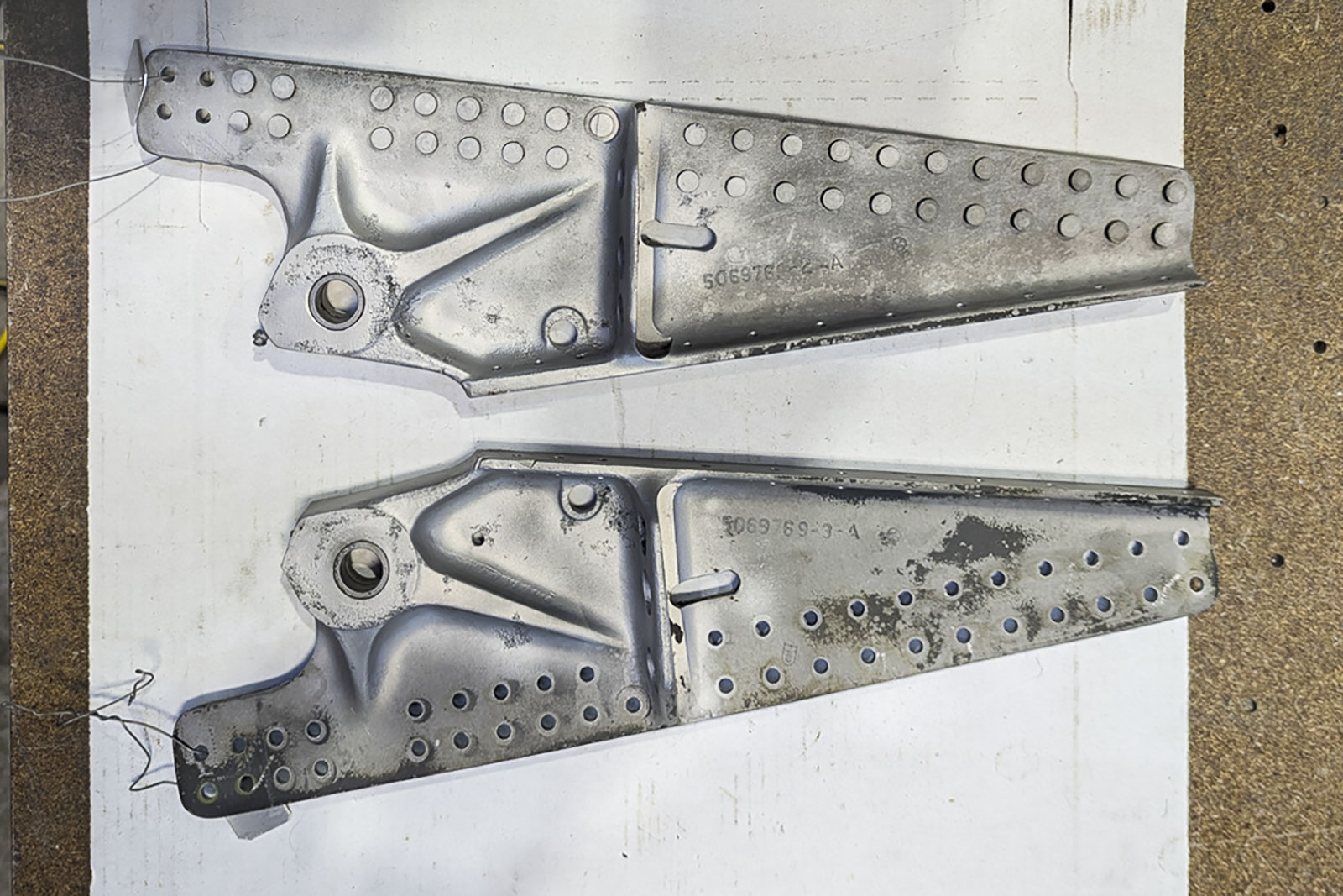 Estes são os suportes de montagem do gancho de retenção; eles se fixam nas longarinas da quilha no Arco de Fuselagem #13. A inspeção após o jateamento revelou alguma corrosão ao redor dos orifícios pivôs principais; está pendente uma decisão sobre se isso pode ser removido sem tornar as peças impróprias para uso aeronáutico. (imagem via Pioneer Aero Ltd.)