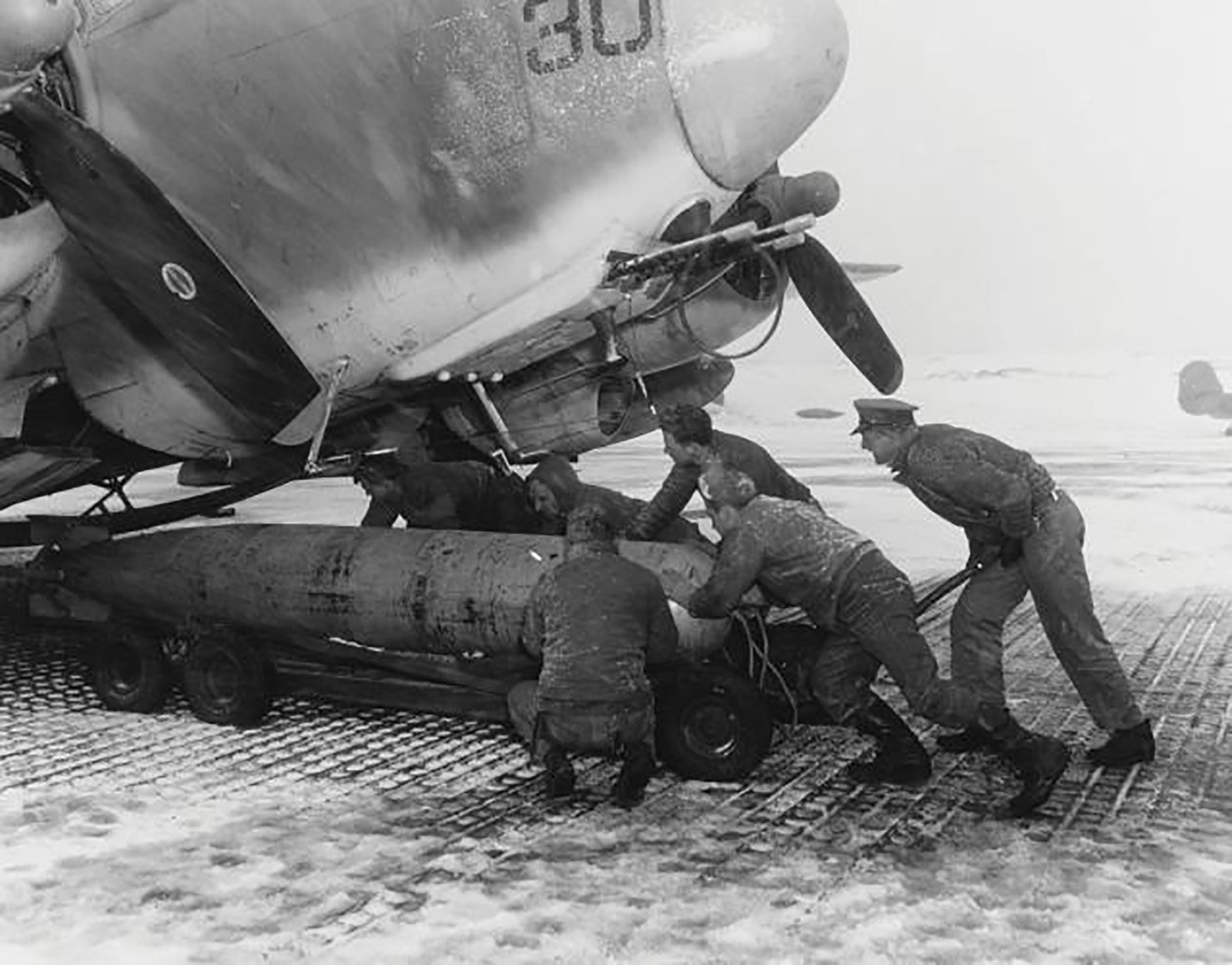 Tripulantes da Marinha carregando um torpedo a bordo de um PV-2 em uma base nas Ilhas Aleutas em preparação para um ataque contra navios japoneses próximos às Ilhas Curilas em abril de 1945. As condições semelhantes às do Ártico deviam ser horríveis de enfrentar, e ainda assim a aeronave realizava suas missões nessas condições. Um radar AN/APS-3 montado no nariz ajudava as tripulações a localizar e atacar embarcações inimigas, mas também auxiliava na navegação e homing. (imagem via Naval History and Heritage Command)