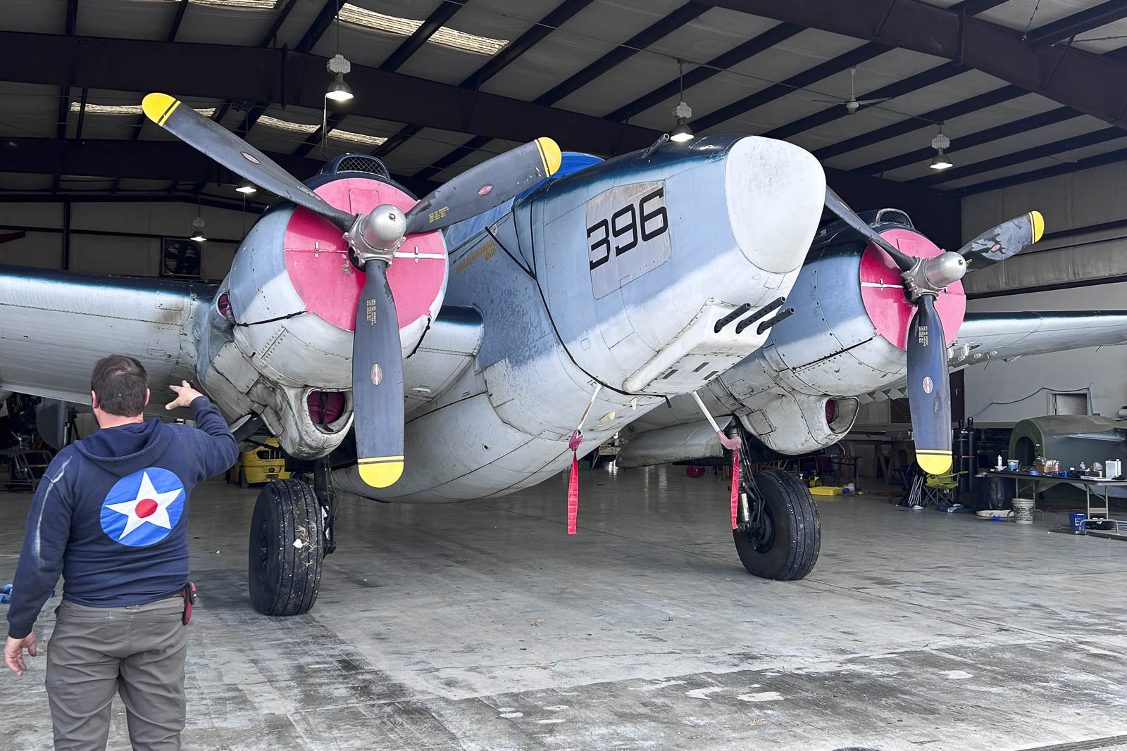 Cody Busse guiando o operador do reboque ao mover o Harpoon para dentro do hangar do Fighter Factory no Suffolk Executive Airport. (imagem por Sid Barteau)